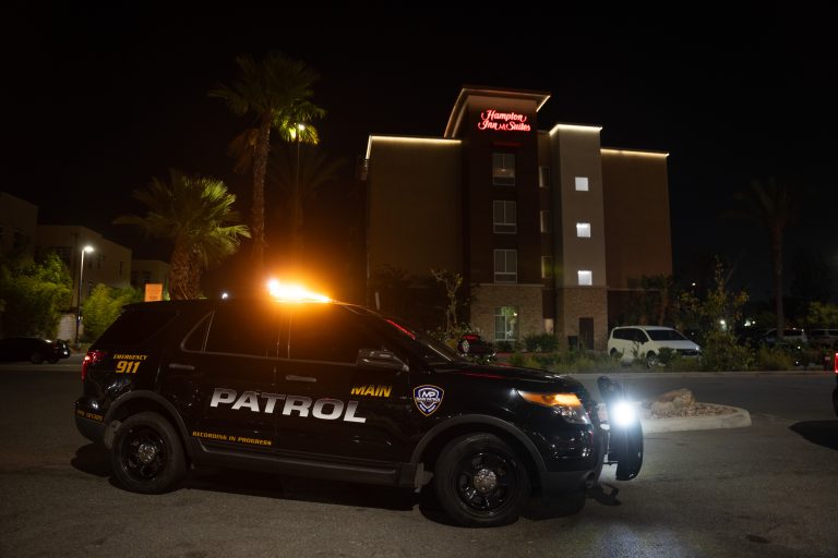 Main Patrol vehicle with emergency lights at a hotel at night