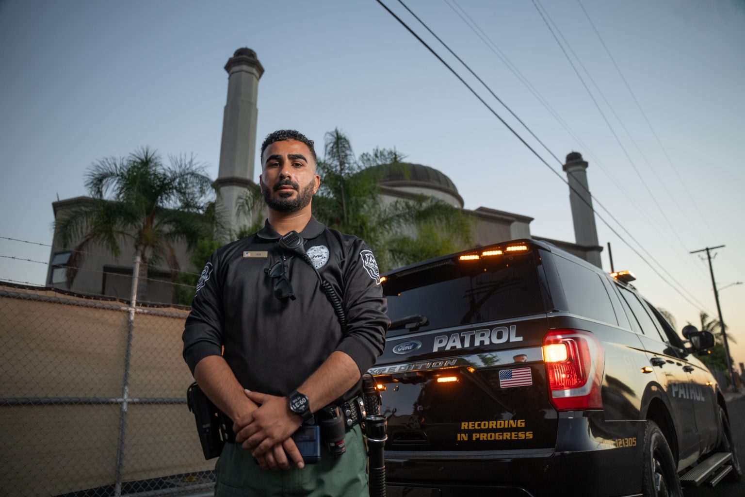 Main Patrol officer standing beside a marked patrol vehicle