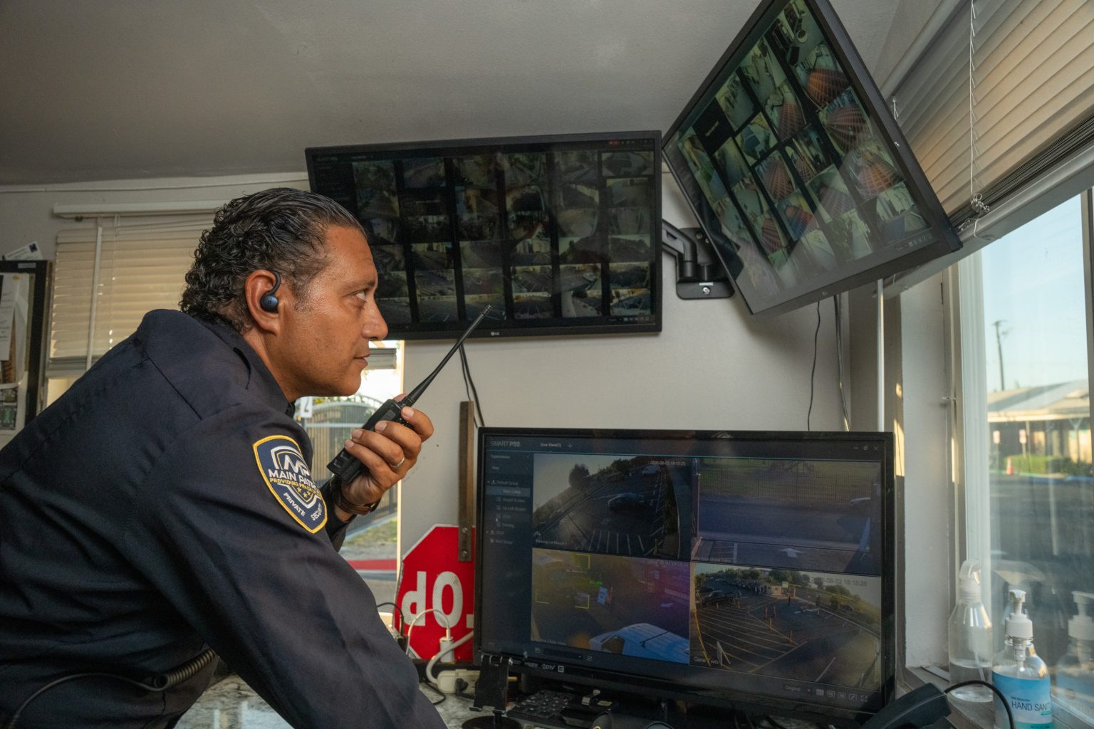 Main Patrol officer with radio monitoring cameras from a guard booth