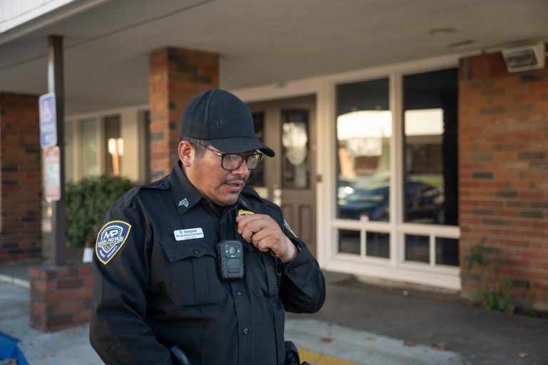 Main Patrol officer with body camera using his radio at a commercial property