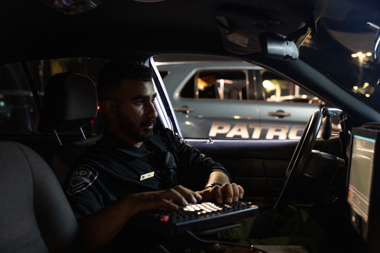 Main Patrol officer writing a digital report inside the patrol vehicle