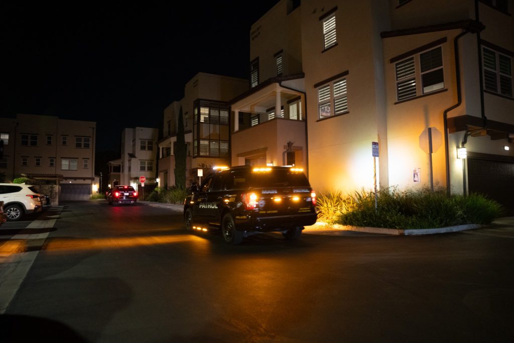 Main Patrol patrol vehicle with amber lights in a townhome community at night